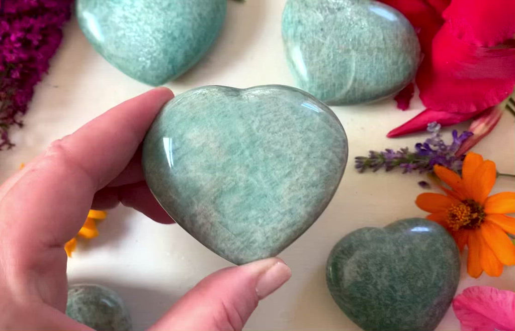 Hand showing light green crystal hearts about 2 inches big.